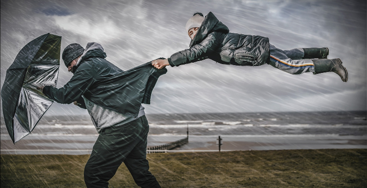 two people walking in heavy wind