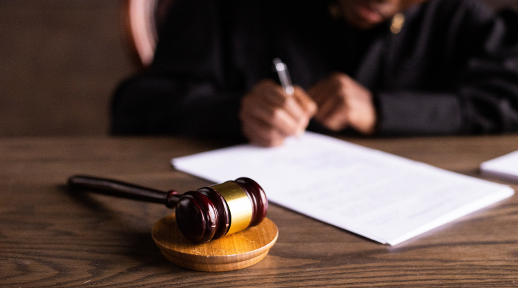 Homeowner Sues for £200,000 After Finding Japanese Knotweed on Property, image of judge signing legal papers, gavel in foreground